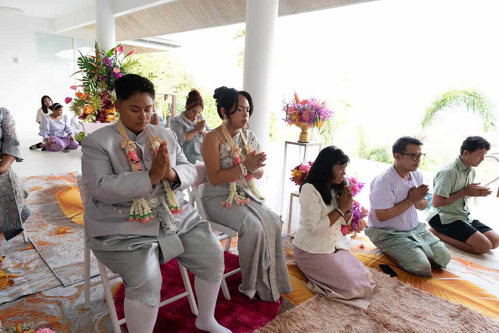 A Thai monk Buddhist wedding blessing on Phuket, with the couple seated before the monks.