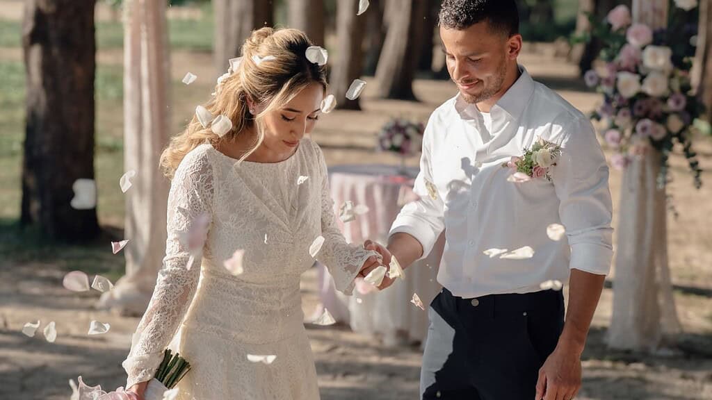 An intimate beach elopement on Phuket with the couple beneath a small floral arch.