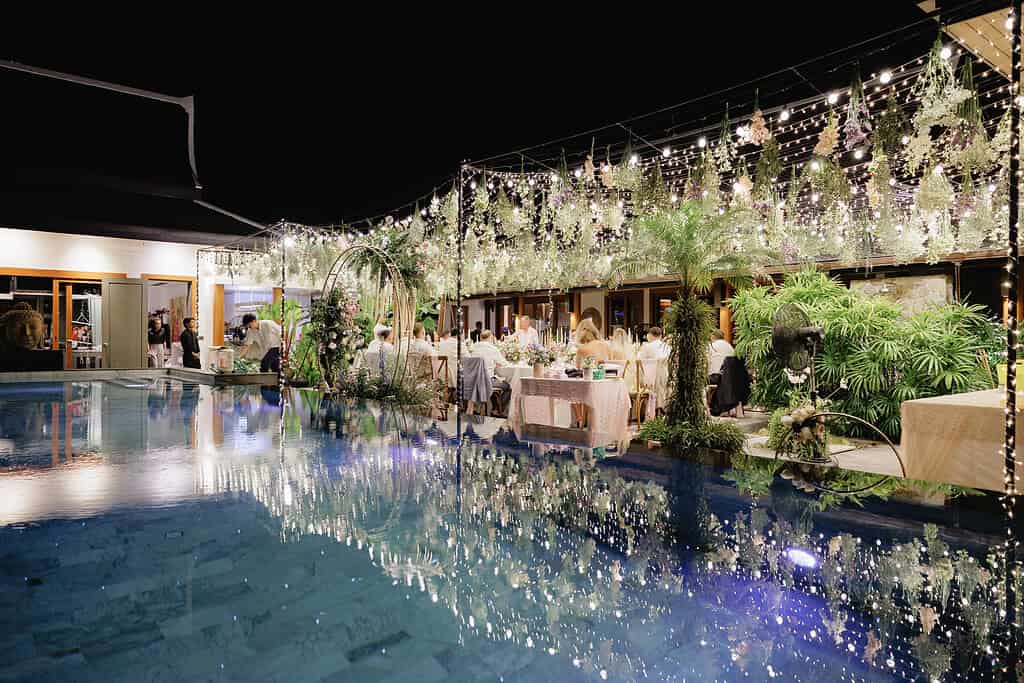 A private villa wedding on Phuket, with tables set against the pool and the sea beyond.
