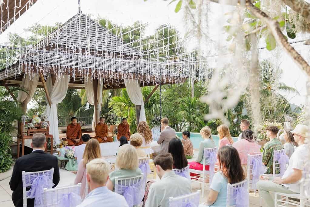 A Thai monk Buddhist wedding blessing on Phuket, with the couple seated before the monks.